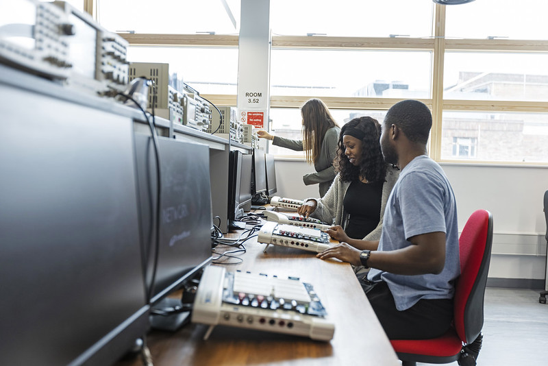 Students work at a row of computers