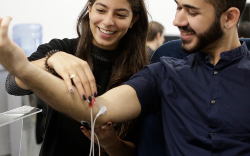 A woman attaching a monitor to a man's arm