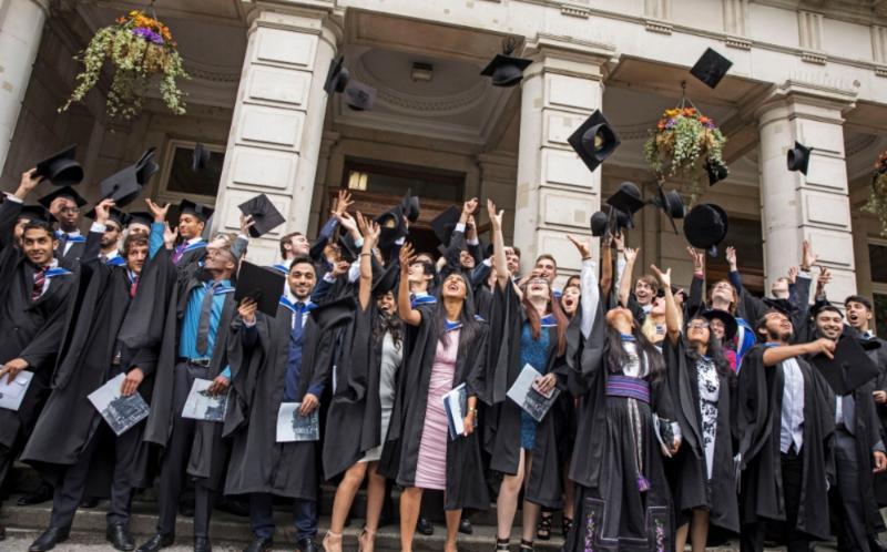 A group of Queen Mary graduates at graduation outside the Queens' Building