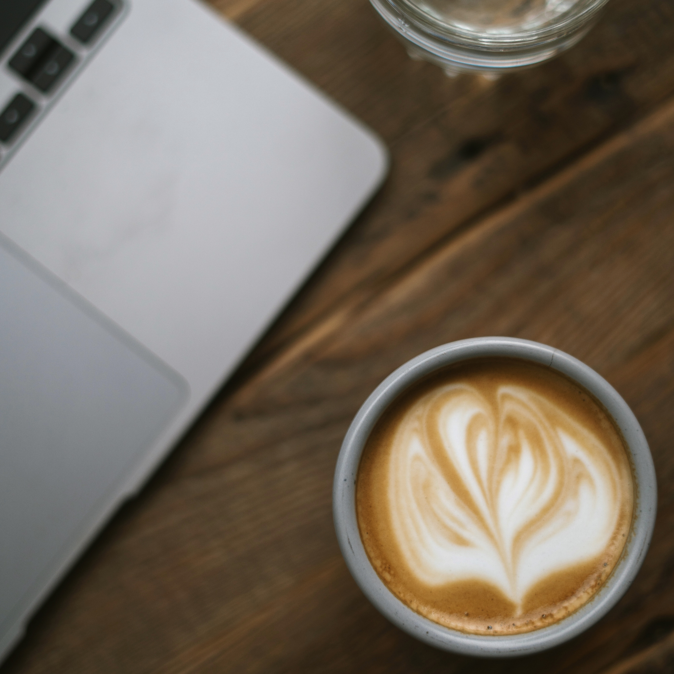 A cup of coffee next to an open laptop