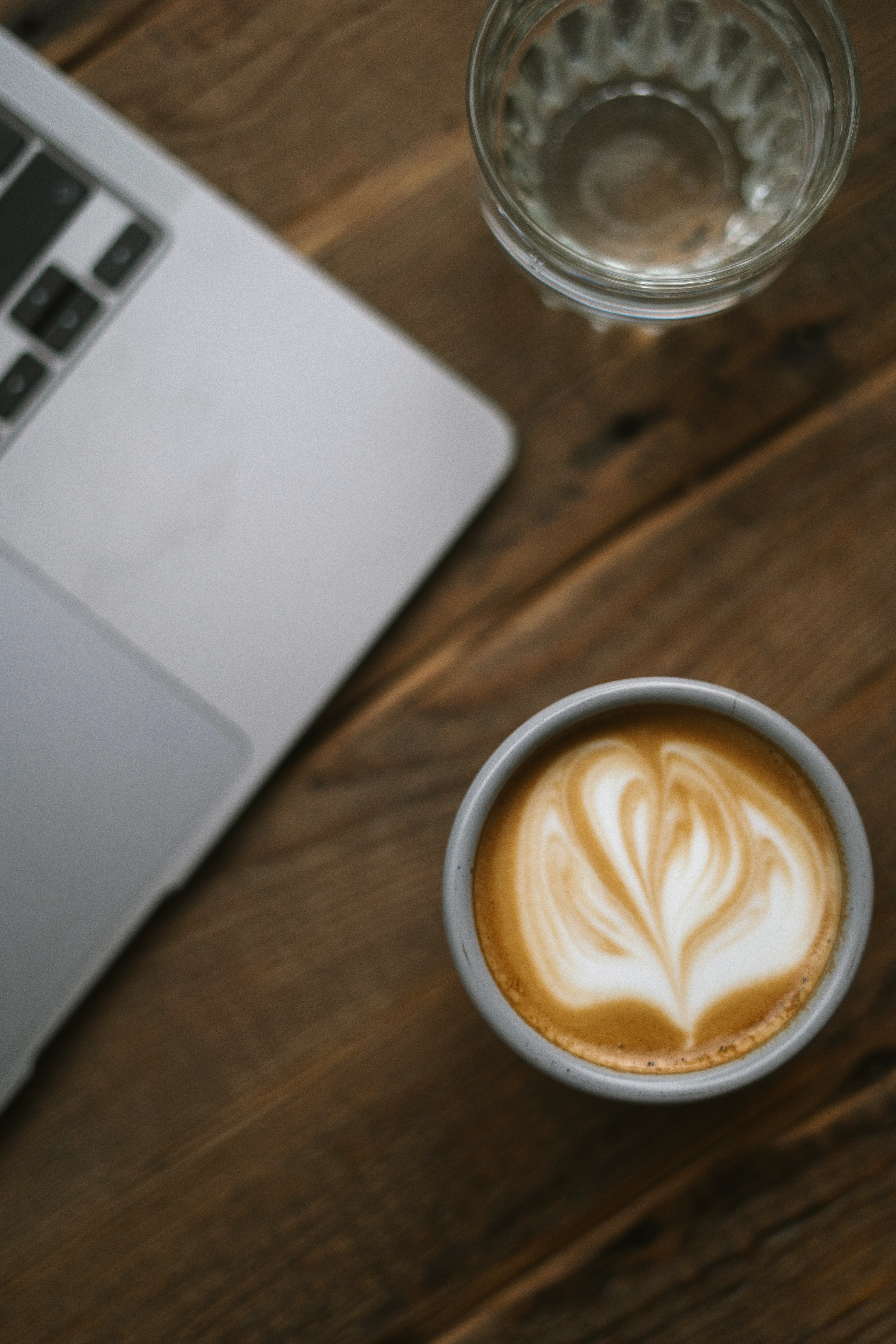 A cup of coffee next to an open laptop