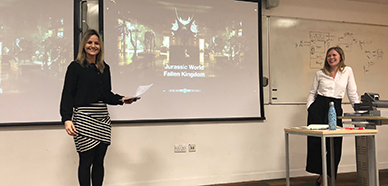 Female lecturer standing by screen