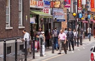 Members of the public walking along a road in east London