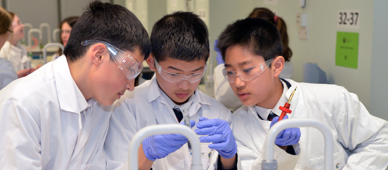 Students in lab coats carrying out an experiment at the Salter's Festival 2019