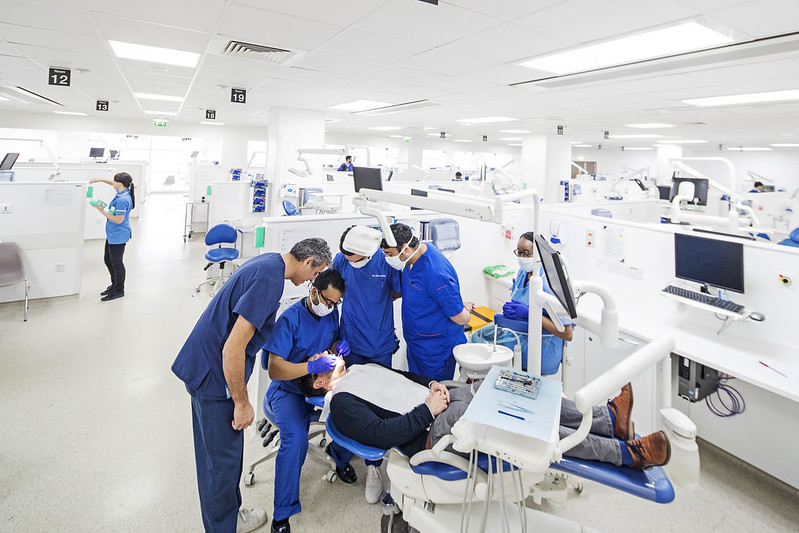 Dental students examining a patient