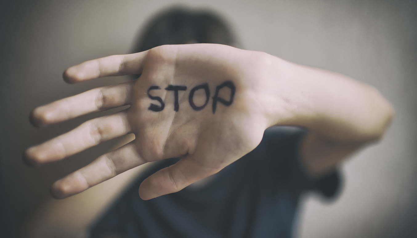 Palm of a person with the word 'stop' written on it in black ink