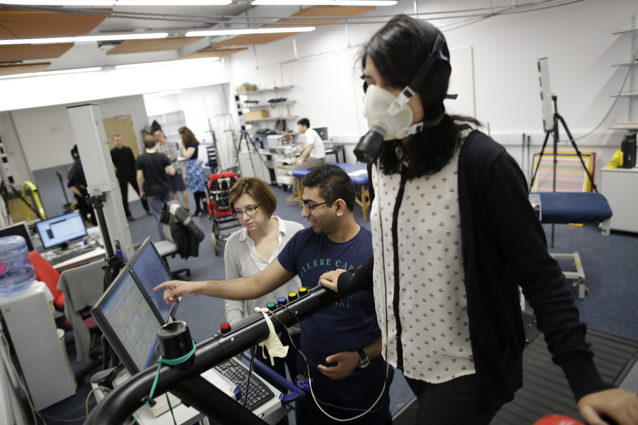 Person walking on a treadmill while wearing a mask