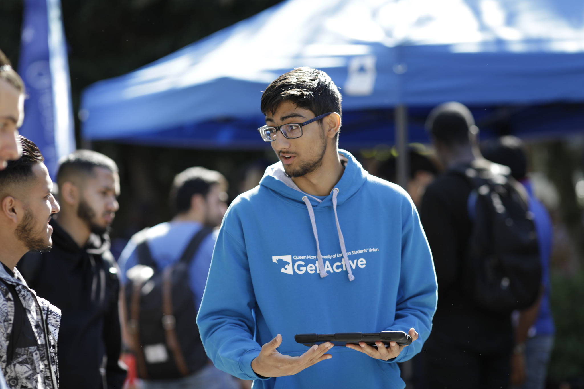 Student speaking to others while holding an ipad