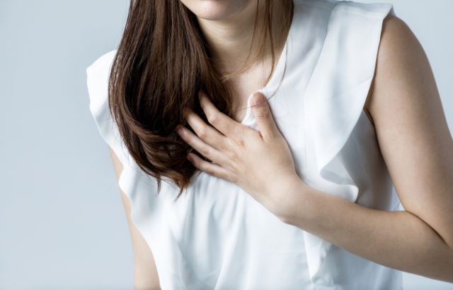 Woman placing hand on her chest - Image by Adobe Stock