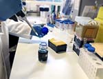 Researcher holding a pipette in a laboratory.