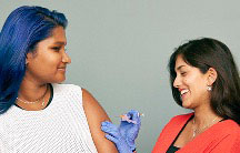 A nurse preparing an injection needle for female patient