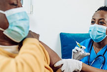 A nurse preparing a needle injection for female patient